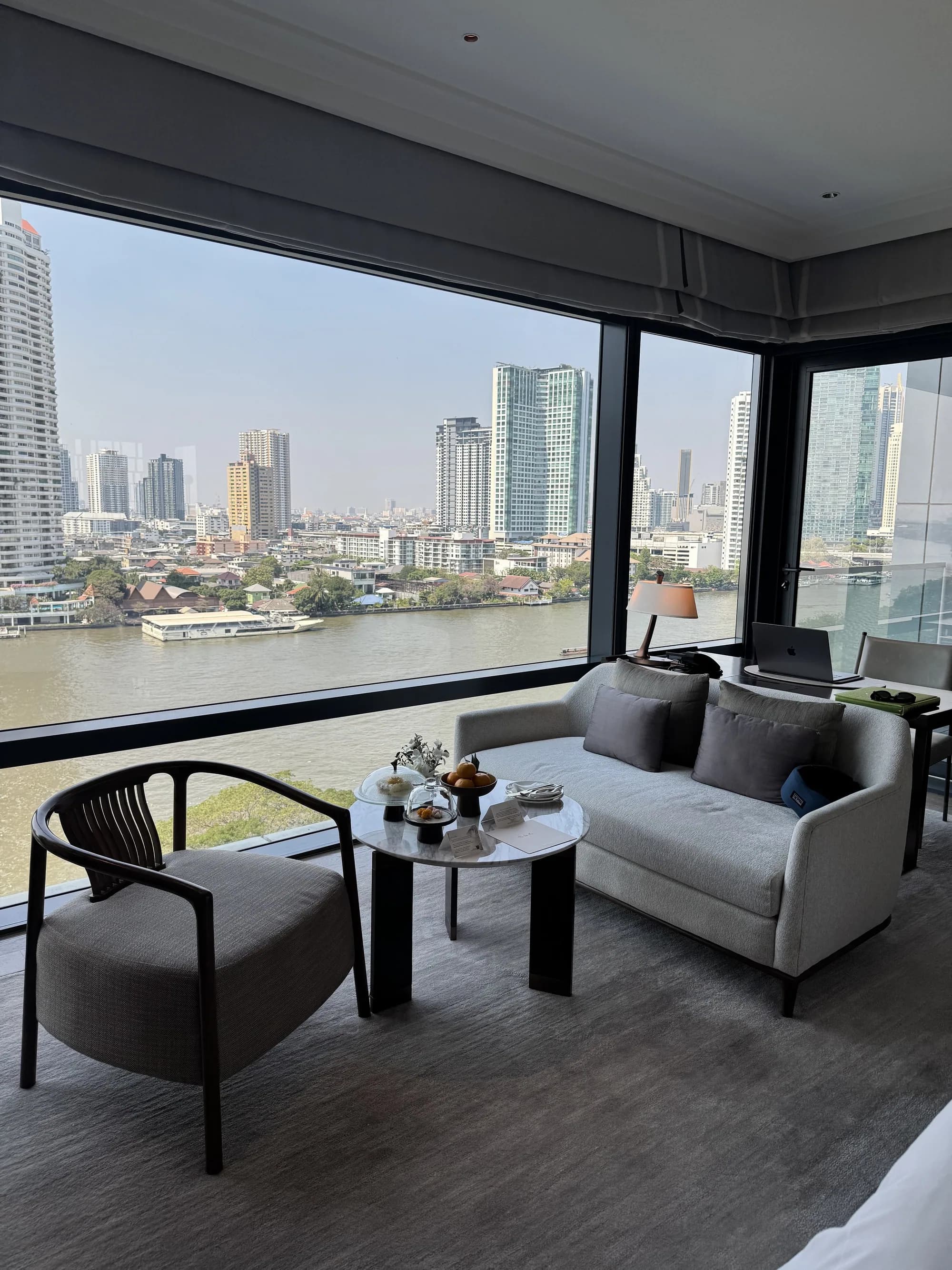 River-facing seating area inside a Capella Bangkok guest room