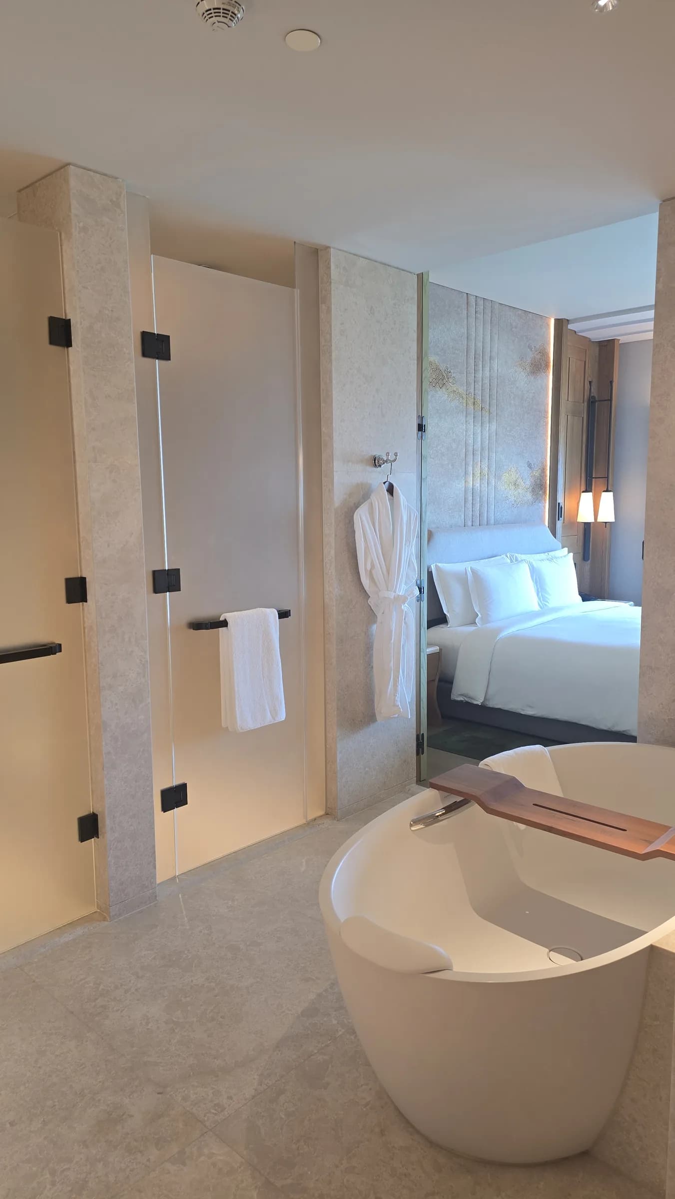 The bath area sits close to the bed, making the Deluxe room feel more open without looking showy.