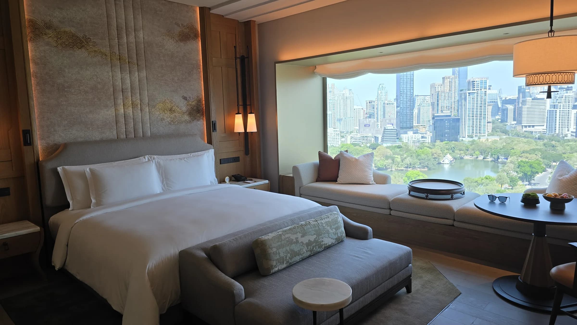 The bed and park view in one frame explain why the room felt calm immediately after arrival.