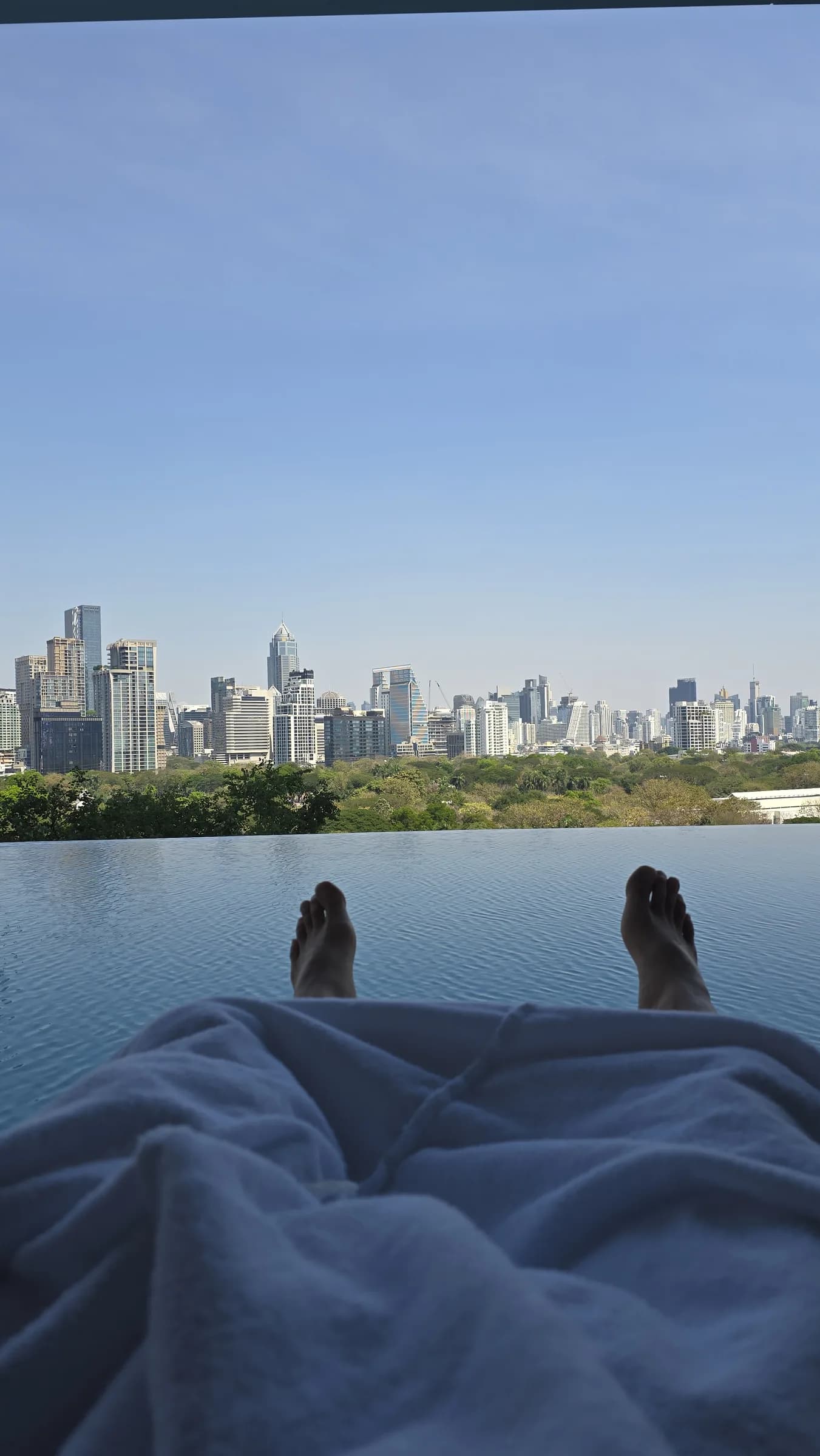 This is the pool-resting angle: daybed, open air, and the park-facing city mood.