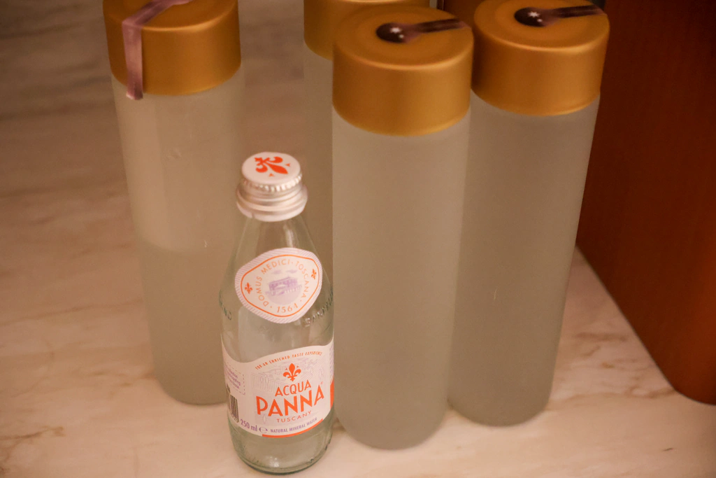 Acqua Panna بجانب زجاجة ماء الفندق بشعار كابيلا.