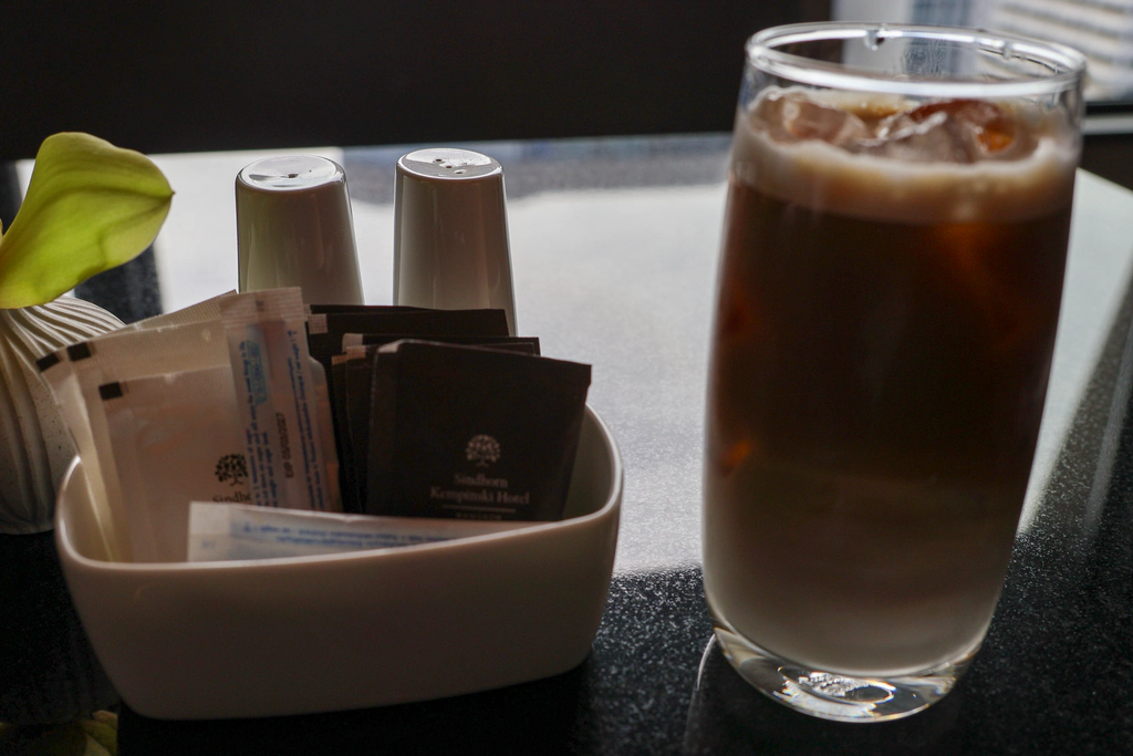 กาแฟเย็นข้างซองโรงแรมและภาชนะเครื่องปรุงขาว