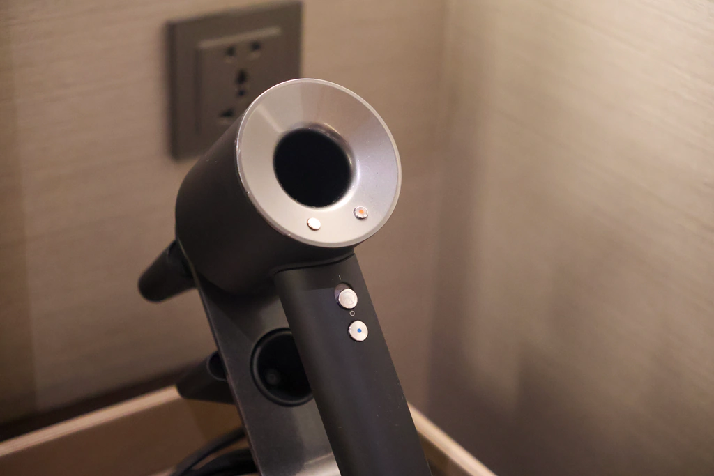 ภาพใกล้หัวกลมกับตัวควบคุมบนด้ามไดร์ Dyson