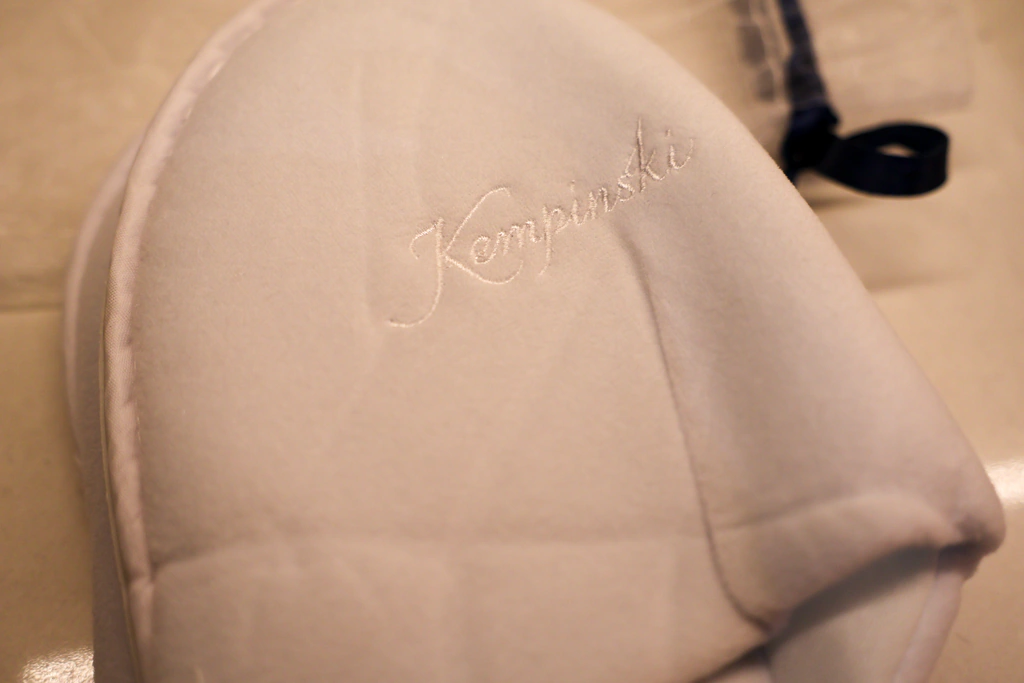 ตัวปัก Kempinski สีขาวบนรองเท้าแตะขาว