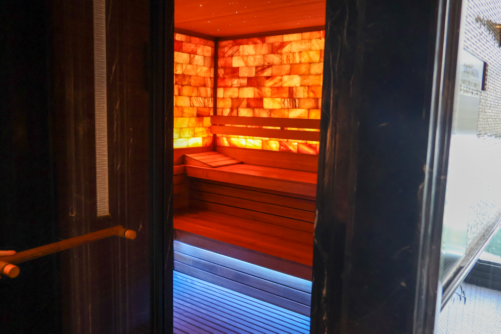 ทางเข้า Salt Sauna ที่เห็นผนังเกลือส้มกับไฟน้ำเงิน