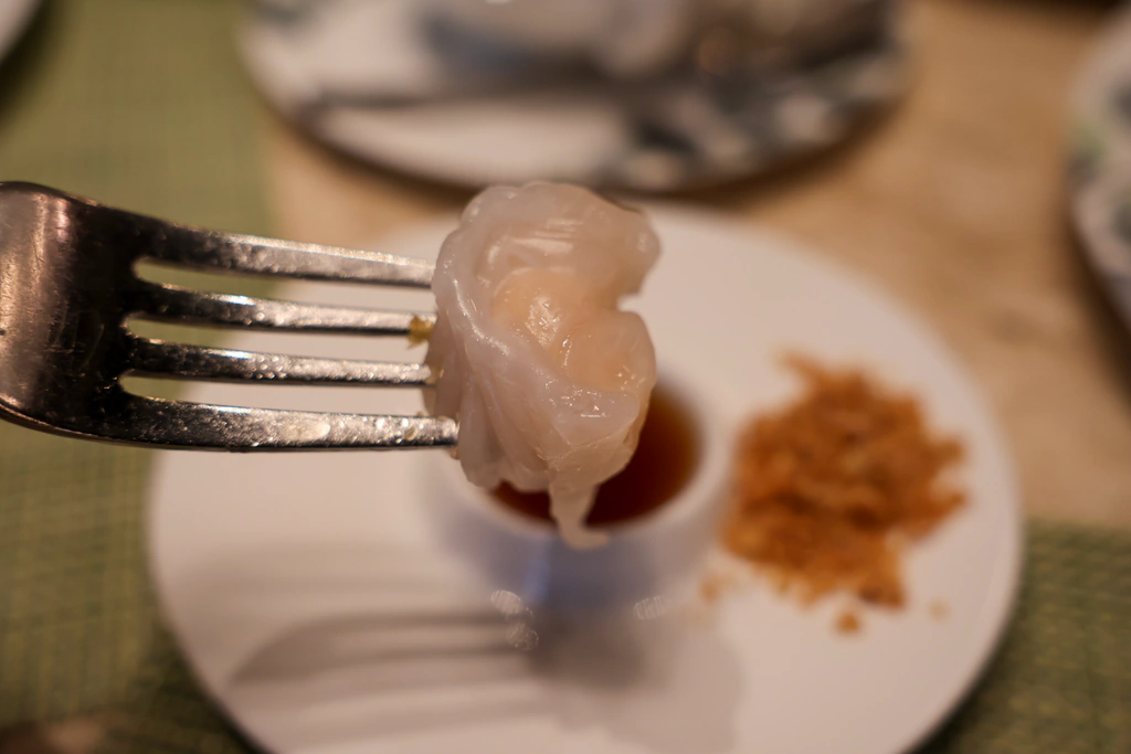ติ่มซำบนส้อมที่เห็นแป้งโปร่งและรอยจีบ