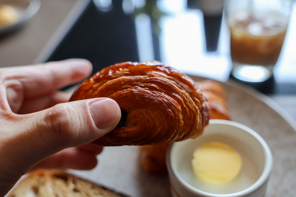 ปลาย Pain au Chocolat ที่ยกขึ้นให้เห็นช็อกโกแลตและชั้นแป้ง