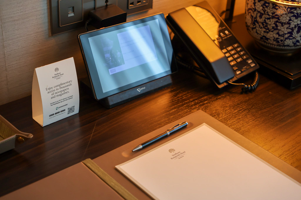 แท็บเล็ต SuitePad และการ์ด PressReader ข้างโทรศัพท์