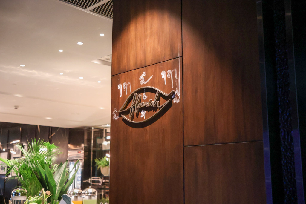 ชื่อ Flourish ในกรอบรูปใบไม้ตรงทางเข้า