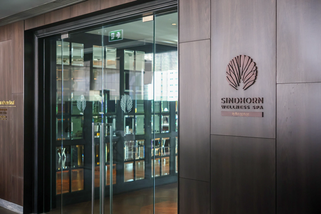 ชื่อ Sindhorn Wellness Spa by Resense และลายพัดบนทางเข้า