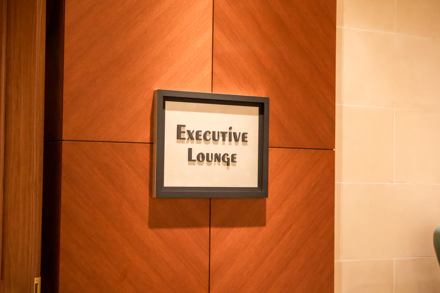 لافتة Executive Lounge على جدار مكسو بالخشب