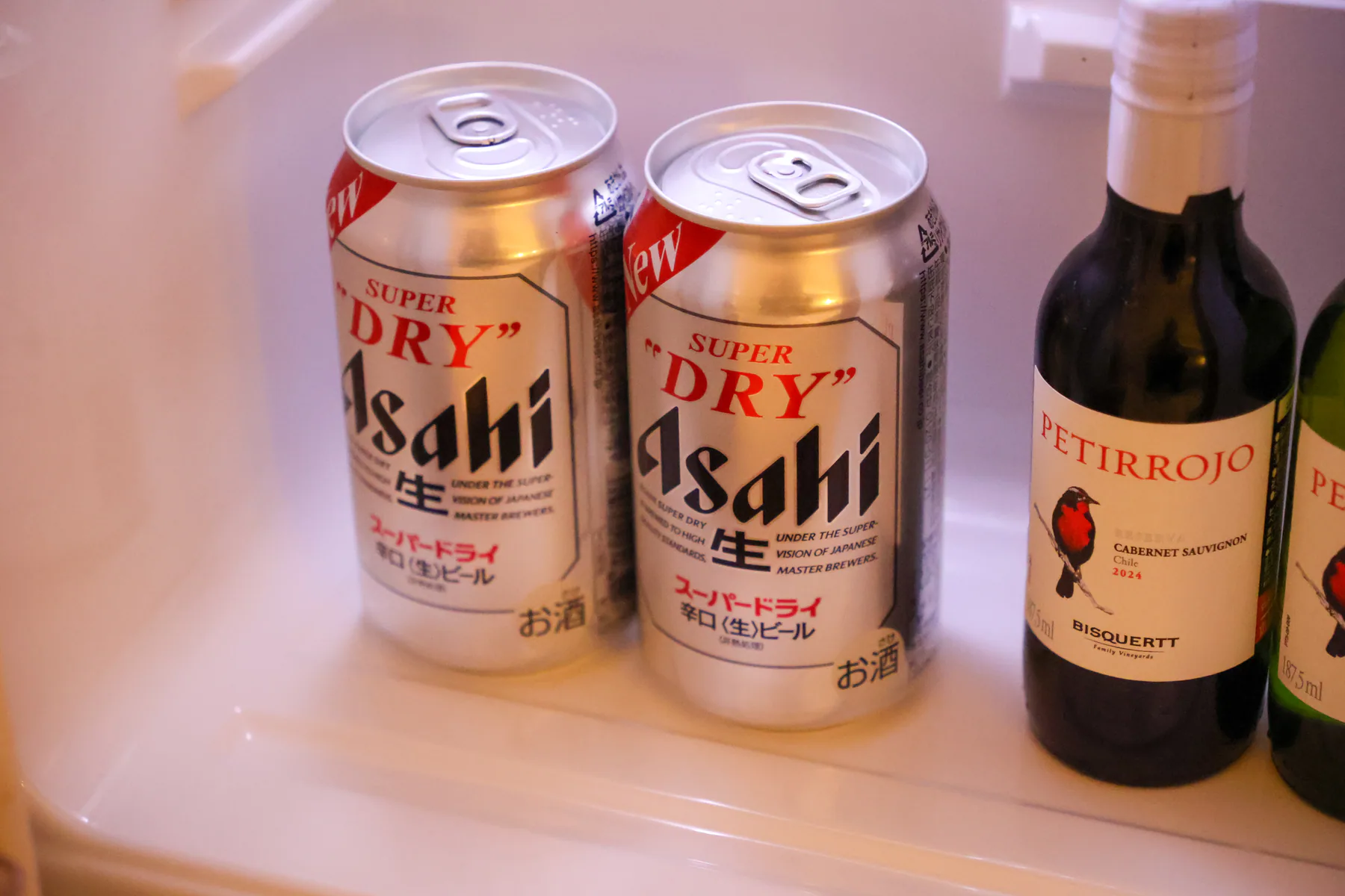عبوتا بيرة Asahi وزجاجتان صغيرتان من النبيذ الأحمر والأبيض