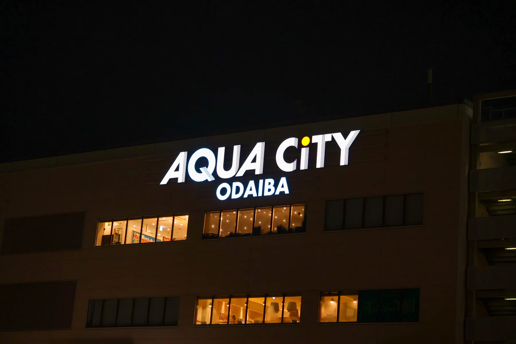 لافتة AQUA CiTY ODAIBA مضاءة ليلًا